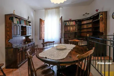 a dining room with a table and chairs and bookshelves at Appartamenti Esther in San Vito lo Capo