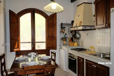 a kitchen with a table and a stove top oven at Appartamenti Esther in San Vito lo Capo