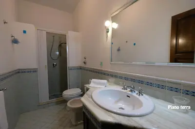 a bathroom with a sink and a toilet and a mirror at Appartamenti Esther in San Vito lo Capo