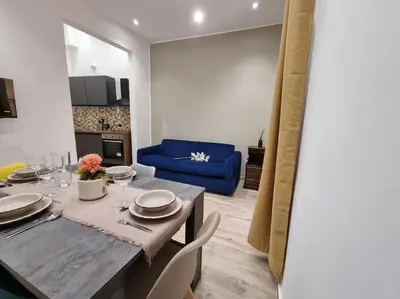 a dining room with a table and a blue couch at Il Mio Canto Home in Palermo