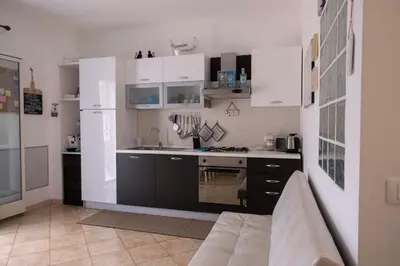 a kitchen with white cabinets and a sink and a stove at Cefalù, Lascari - Appartamento moderno vicino al mare in Lascari