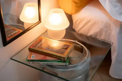 a book on a glass table next to a bed at Cefalù, Lascari - Appartamento moderno vicino al mare in Lascari