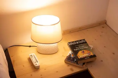 a table with a lamp and a book and a remote control at Cefalù, Lascari - Appartamento moderno vicino al mare in Lascari