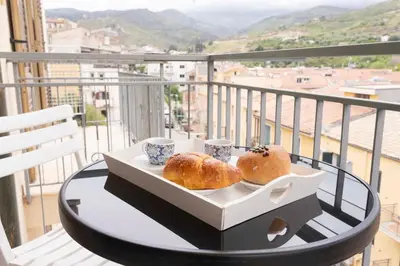 a table with two pastries and two cups on a balcony at Cefalù, Lascari - Appartamento moderno vicino al mare in Lascari