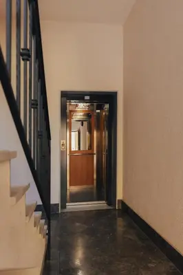 an empty hallway with a wooden door and stairs at Anna&Micky town house in Santa Flavia