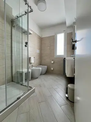 a bathroom with two tubs and a glass shower at NOVIMO Comfort Apartment with elevator & secure privat parking in Terrasini