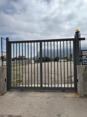 a metal gate with a view of a beach at NOVIMO Comfort Apartment with elevator & secure privat parking in Terrasini