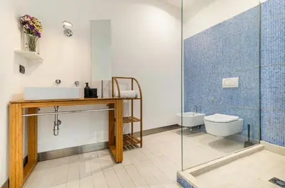 a bathroom with a toilet and a glass shower at GuestHost - La Cala Sea View Apartment with Balconies in Palermo