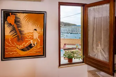a picture on a wall with a picture of a woman in a boat at Le Scalette in Castellammare del Golfo