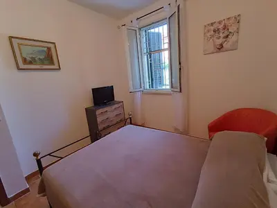 a bedroom with a bed and a television and a window at Le Tremar Carini Poseidon in Carini
