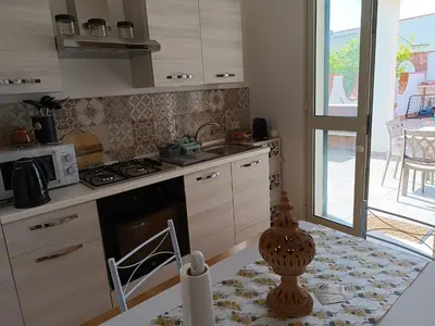 a kitchen with a stove top oven next to a window at Le Tremar Carini Poseidon in Carini