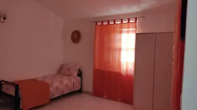 a bedroom with a bed and a red curtain at Sizilien 2 in Trappeto