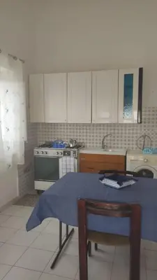 a kitchen with a table with a blue table cloth on it at Sizilien 2 in Trappeto