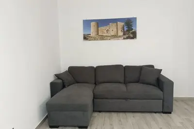a couch in a living room with a picture on the wall at Il Tramonto - BALESTRATE in Balestrate