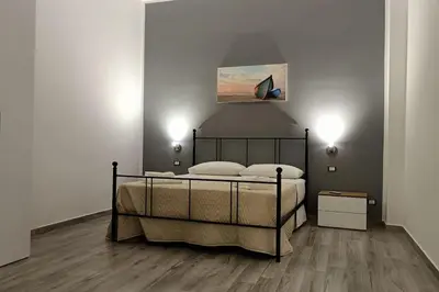 a bedroom with a bed and a painting on the wall at Il Tramonto - BALESTRATE in Balestrate