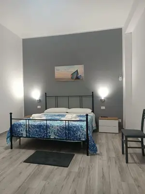 a bedroom with a bed and a table and a chair at Il Tramonto - BALESTRATE in Balestrate