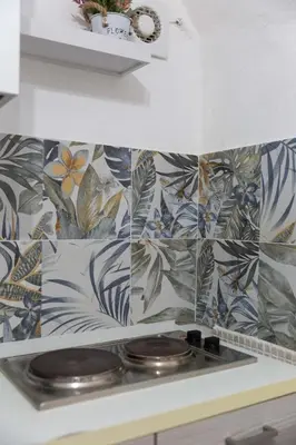 a kitchen with a stove with a bunch of tiles at appartamento centro storico - La casuzza alla Cala in Palermo