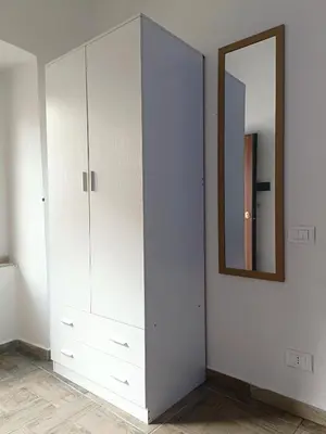 a bedroom with white cabinets and a mirror at appartamento centro storico - La casuzza alla Cala in Palermo