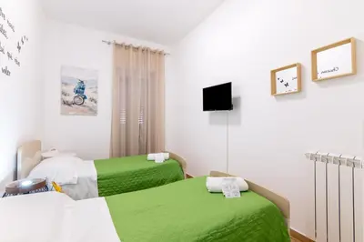 two beds in a room with green and white at Stabile 38 Apartments in Palermo
