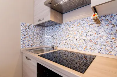 a kitchen with a sink and a tile wall at Stabile 38 Apartments in Palermo