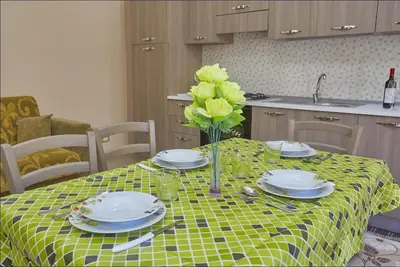 a table with plates and a vase with yellow flowers on it at Casa Maria Stella Scopello in Scopello