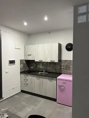 a kitchen with a sink and a pink refrigerator at Vespro House in Palermo