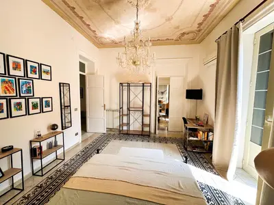 a bedroom with a bed and a chandelier at Da Cosimo U pitturi in Palermo