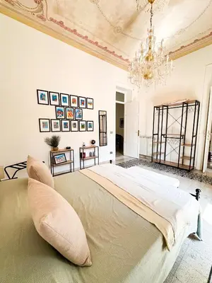 a bedroom with a large bed with a chandelier at Da Cosimo U pitturi in Palermo