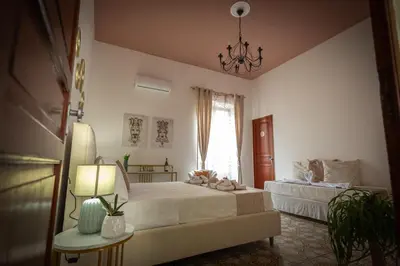 a bedroom with two beds and a chandelier at Scalini holiday in Castellammare del Golfo