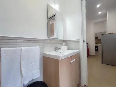 a bathroom with a sink and a mirror and towels at Politeama my Suite in Palermo
