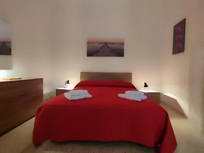 a bedroom with a red bed with two towels on it at Politeama my Suite in Palermo