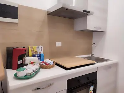 a kitchen with a counter with a cutting board and a sink at Politeama my Suite in Palermo