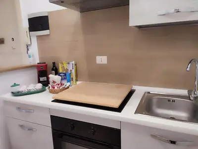 a kitchen counter with a cutting board and a sink at Politeama my Suite in Palermo