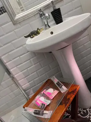 a bathroom with a white sink and a wooden table at Ninohouse in Palermo