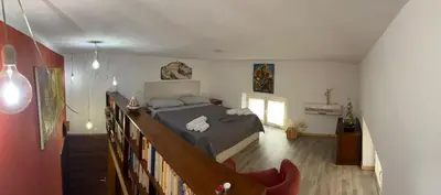a bedroom with a bed and a staircase in a room at Ninohouse in Palermo