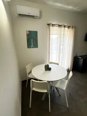 a dining room with a white table and chairs at Il falchetto in Palermo