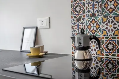 a coffee pot sitting on a counter next to a table at Lumar Sicilia - Magione in Palermo