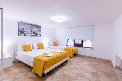 a bedroom with two beds and two tables at Lumar Sicilia - Cattedrale in Palermo