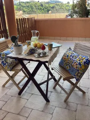 a table and chairs with fruit on a patio at Casa iusu - Home with patio near the sea and Palermo in Casteldaccia