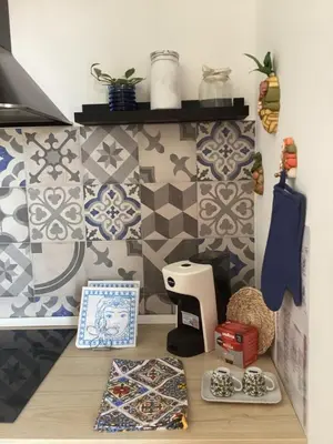 a room with tiles on the wall and a table with ties at Casa iusu - Home with patio near the sea and Palermo in Casteldaccia