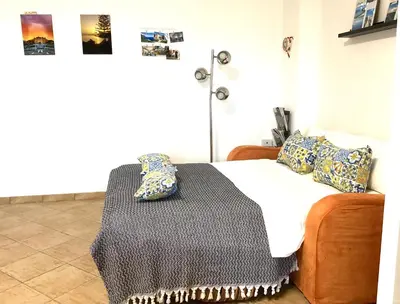 a bedroom with a bed with a blanket and pillows at Casa iusu - Home with patio near the sea and Palermo in Casteldaccia