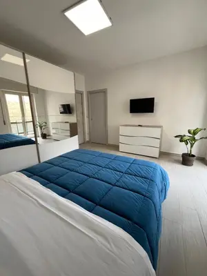 a bedroom with a large bed with a blue blanket at Nela Appartament in Bagheria