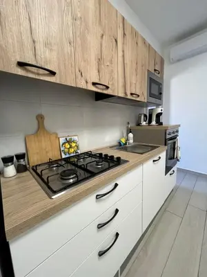a kitchen with white cabinets and a stove top oven at Nela Appartament in Bagheria