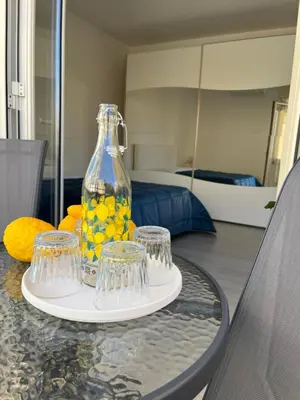a table with a glass vase and four cups on it at Nela Appartament in Bagheria