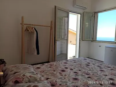 a bedroom with a bed and a large window at Mediterraneo Rooms in Castellammare del Golfo