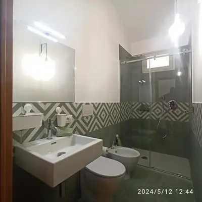 a bathroom with a sink and a toilet and a shower at Mediterraneo Rooms in Castellammare del Golfo