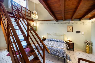 a staircase in a bedroom with a bed and a stair case at Francy House in Termini Imerese