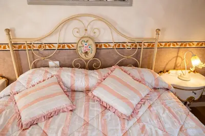 a bed with pink and white pillows on it at Francy House in Termini Imerese