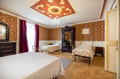 a bedroom with two beds and a chandelier at Francy House in Termini Imerese