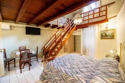 a bedroom with a bed and a wooden staircase at Francy House in Termini Imerese
